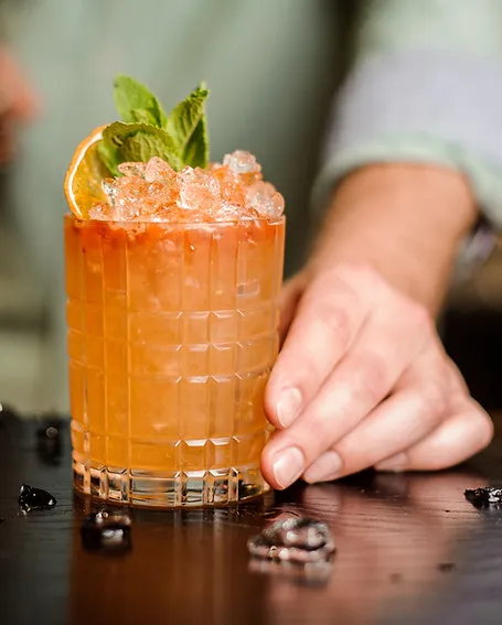 A hand-crafted citrus cocktail garnished with fresh mint